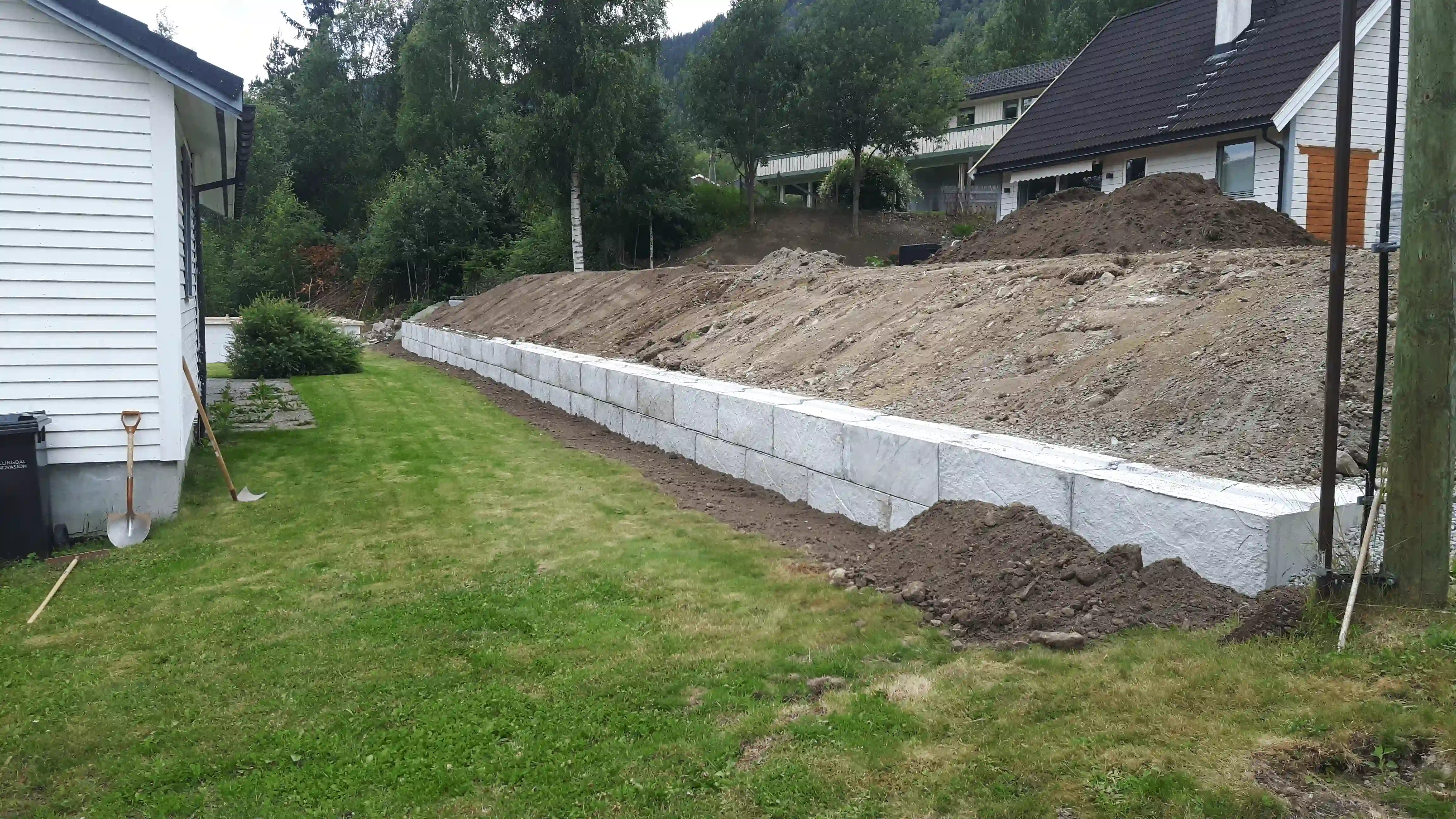 Betongblokker lagt i mur nedenfor en liten bakke